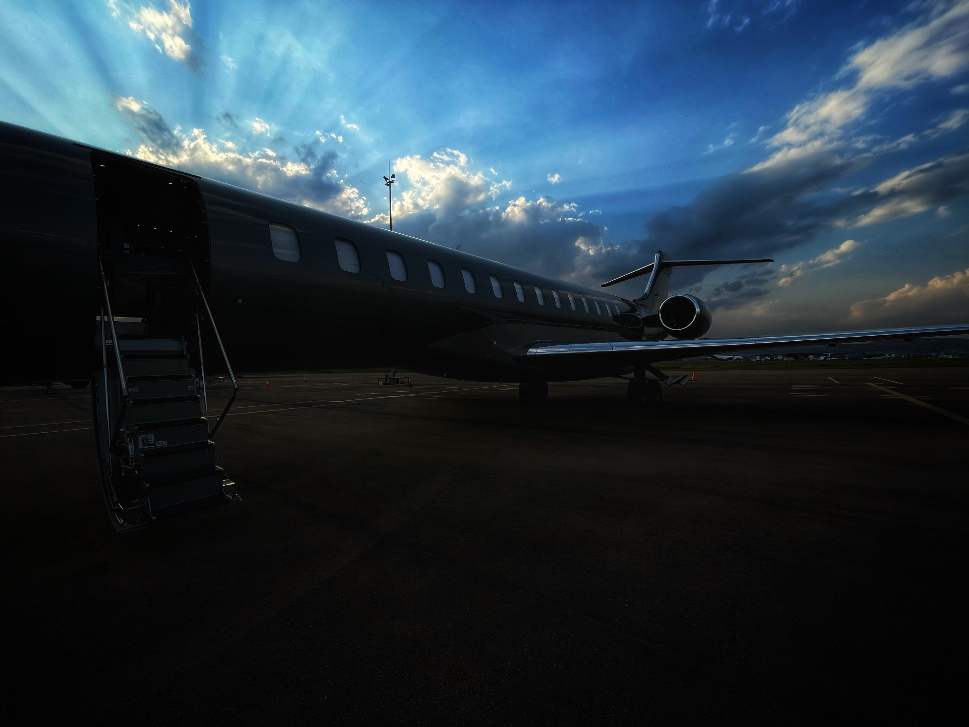 Private jet silhouette against dramatic sky
